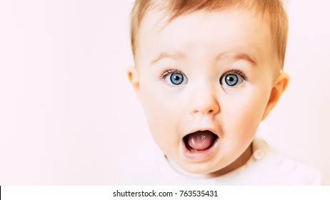 Surprised happy beautiful blue-eyed baby isolated on white