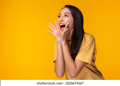 Surprised happy beauty asian woman looking copy space in excitement. Expressive facial expressions. Presenting some product. Beautiful girl act like a telling secret Isolated on yellow background - Shutterstock ID 1820674367