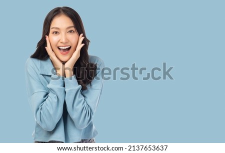 Surprised happy beauty asian woman looking camera in excitement Expressive facial expressions Presenting a product Beautiful girl act like a telling something Isolated on light blue background