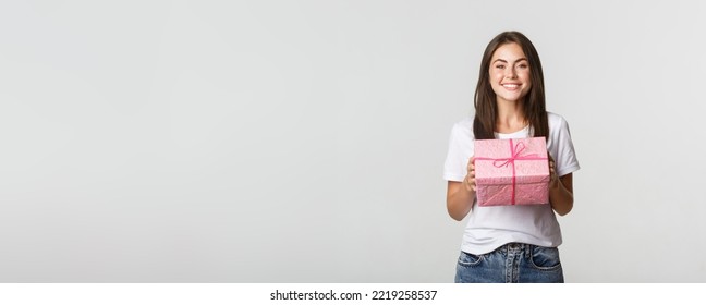 Surprised Happy Birthday Girl Receiving Wrapped Gift, White Background.