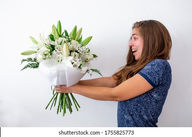 Surprised And Happy Caucasian Young Girl Receiving Bouquet Of Flowers. Surprise Valentine's Or Anniversary Gift