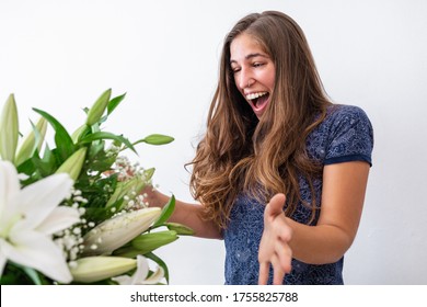 Surprised And Happy Caucasian Young Girl Receiving Bouquet Of Flowers. Surprise Valentine's Or Anniversary Gift