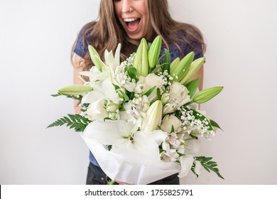 Surprised And Happy Caucasian Young Girl Receiving Bouquet Of Flowers. Surprise Valentine's Or Anniversary Gift