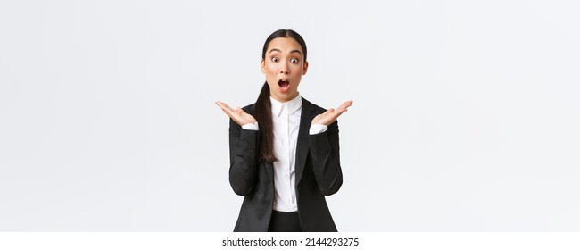 Surprised And Happy Female Team Lead, Manager In Office Wearing Suit And Clap Hands Amazed, Hear Great News, Amazing Win. Asian Entrepreneur Standing Pleased, Reacting To Success