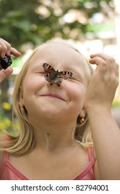Surprised and happy girl with butterfly on nose