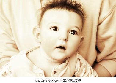 Surprised Infant Baby Boy With Big Blue Eyes And Disheveled Hair, Sepia. Portrait Of A Frightened Child With A Messy Hairstyle, Black And White