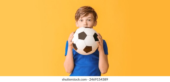 Surprised little boy with soccer ball on yellow background - Powered by Shutterstock