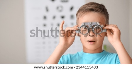 Surprised little boy undergoing eye test in clinic