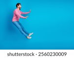 Surprised man in casual clothes appears to float against a bright blue background