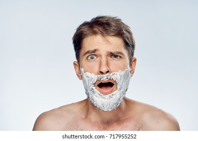 surprised man with foam on his beard on a light background portrait, spa, beauty                                - Powered by Shutterstock