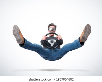 Surprised Man In Goggles In The Air With A Car Steering Wheel In His Hands, On Light Background, Front View. Car Accident Concept.