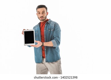 surprised man looking at camera while holding digital tablet with blank screen isolated on white