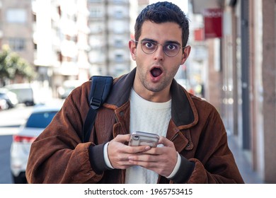 Surprised Man Looking At Mobile Phone On The Street