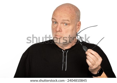 Surprised Middle-Aged Caucasian Man Holding Dark Eyeglasses Frame on White Background - Shocked Expression - Head turned Slightly