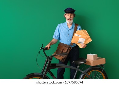 Surprised old postman with bicycle on color background