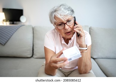 Surprised old woman using mobile phone searching information of medicine label and prescription medications, healthcare and people concept. Woman speaking to her doctor during the COVID-19 pandemic.
