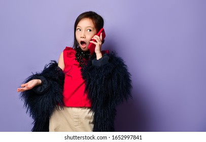 Surprised Rich Asian Korean Girl Kid In Luxury Fashion Clothes Talking On Mobile Cell Phone Using New Popular Red Gadget Chatting  Heard The Shocking News From A Friend On Purple