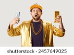 Surprised rich man wearing golden suit, holding a stack of cash, money and a gold bar, celebrating financial success. Wealth and prosperity, portraying a rapper or gangster character.