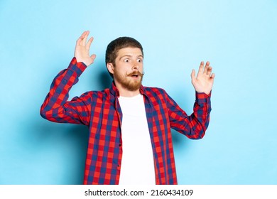 Surprised  shocked  Emotional young red  headed man in white t  shirt   plaid shirt posing isolated blue background  Concept art  fashion  emotions  aspiration  Copy space for ad