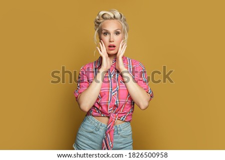 Surprised shocked pinup woman retro model on yellow banner background