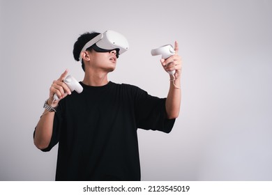 Surprised Teen Male Student Use Vr Glasses And Looks At Empty Space With Gray Background, Studio Shot.Virtual Gadgets For Entertainment, Work, Free Time And Study. Virtual Reality Technology Concept.