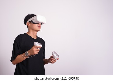 Surprised Teen Male Student Use Vr Glasses And Looks At Empty Space With Gray Background, Studio Shot.Virtual Gadgets For Entertainment, Work, Free Time And Study. Virtual Reality Technology Concept.