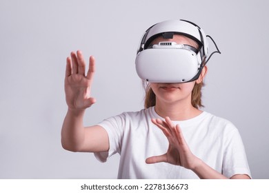 Surprised teen woman student use vr glasses and looks at empty space with gray background. Virtual gadgets for entertainment, work, free time and study. Virtual reality metaverse technology concept. - Shutterstock ID 2278136673