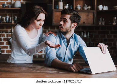 Surprised Wife Spying On Husband With Laptop. Wife Caught Husband Watching Pornographic Videos On Laptop Or Texting With Mistress. Family Quarrel. Concept Of Family Conflict.