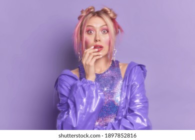 Surprised Woman Dressed In Style Of Nineties For Disco Retro Party Wears Bright Makeup Purple Fashionable Clothes Has Trendy Hairstyle Poses Indoor. Vintage Fashion. Slow Glow Effect. Back To 90s