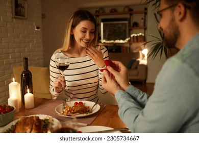 Surprised woman getting a marriage proposal over romantic dinner at home - Powered by Shutterstock