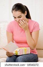 Surprised Woman Holding Birthday Gift And Reading Birthday Card