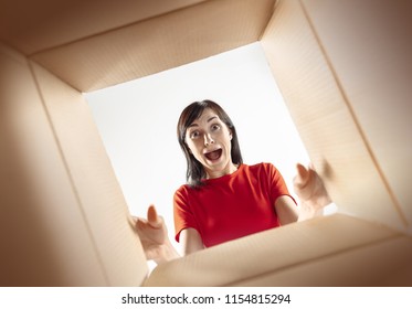 The Surprised Woman Opening Box And Looking Inside. The Package, Delivery, Surprise, Gift, Lifestyle Concept. Human Emotions Concepts