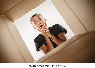 The Surprised Woman Opening Box And Looking Inside. The Package, Delivery, Surprise, Gift, Lifestyle Concept. Human Emotions Concepts