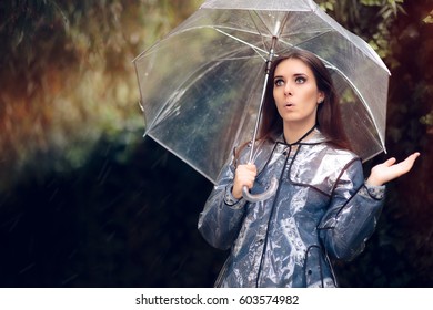 Surprised Woman In Raincoat With Transparent Umbrella
 Lovely Girl Checking For Rain In Spring Natural View 
