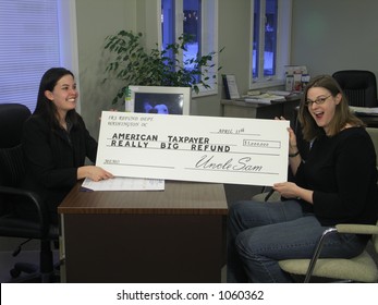 A Surprised Woman Receives An Oversized Tax Refund Check.