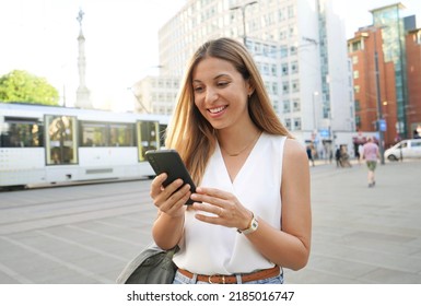 Surprised woman watching on mobile phone in city street - Powered by Shutterstock