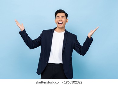 Surprised Worry Free Handsome Asian Man In Semi Formal Clothes Smiling And Opening Hands In Light Blue Isolated Studio Background
