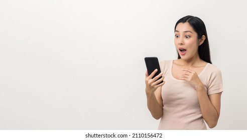 Surprised Young Asian Lady Using Mobile Phone. Very Shocked Face Asia Woman Holding Smartphone. Looking At Cell Phone Screen. Victory Moment. Very Enjoy And Fun Relax Time