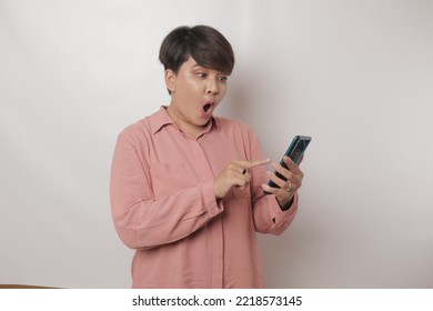 Surprised Young Asian Lady Using Mobile Phone. Very Shocked Face Asia Woman Holding Smartphone. Looking At Cell Phone Screen. Victory Moment. Very Enjoy And Fun Relax Time