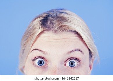 Surprised Young Blonde Woman With Blue Eyes And Thin Brows Over Bright Blue Background. Selfcare And Beauty Concept. Close Up Portrait Of Shoked Blonde Girl