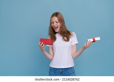 Surprised Young Caucasian Woman Holding Red Gift Box And Shocked With Open Mouth Standing On Blue Background Beautiful Girl Happy Smile Holding Generic Box Suitable For Any Holiday Use For Advertising