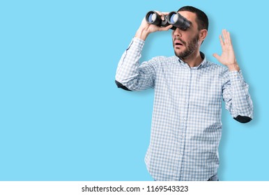 Surprised young man using a binoculars