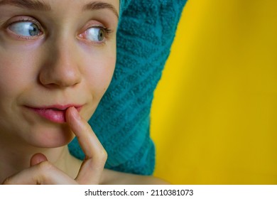 Surprised Young Woman With Green Towel Over Head On Yellow Background Looks Slyly With Interest To The Right. Space For Text., Grooming, Spa Bath, Natural Beauty Concept. Girl Pulling Finger To Mouth.