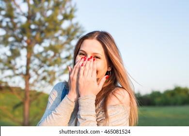 Surprised Young Woman With Hands Over Her Mouth Outdoor