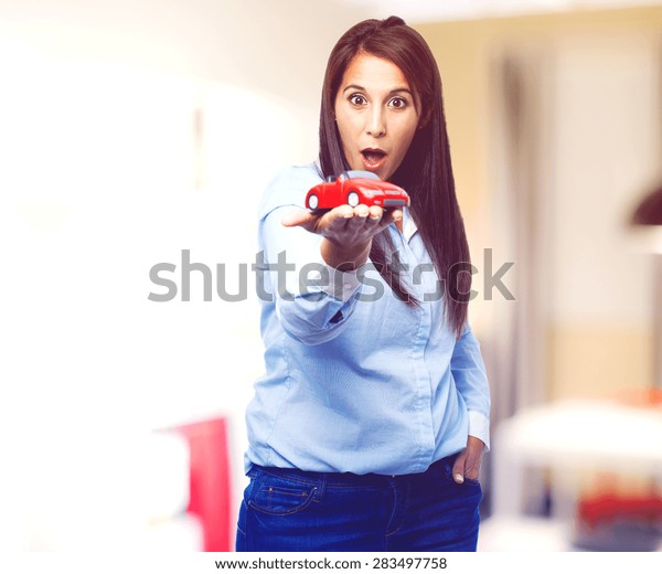 surprised young woman with red\
car
