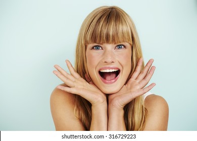 Surprised young woman smiling in studio