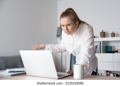 Surprised Young Woman Spying Coworker's Laptop