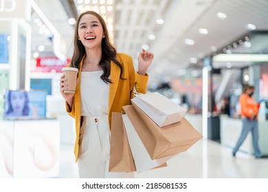 surprising cheerful asian female adult woman shopper hand hold shopping bag and coffee paper cup walking buying cloths in department store shopping mall with happiness exited toothy smiling joyful - Powered by Shutterstock