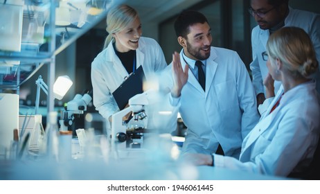Surprized Female Reseach Scientist Makes an Important Discovery While Researching Samples Under the Microscope. Happy Colleagues Give High Five and Share Success with Fellow Bioengineers. - Shutterstock ID 1946061445