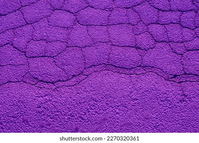 Surreal background of purple cracked asphalt. Texture.